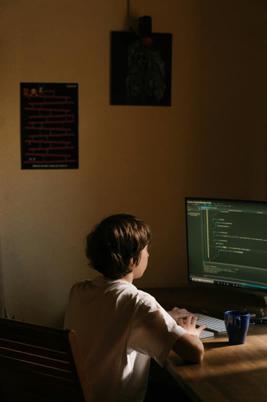 Man coding on a computer in a dark room